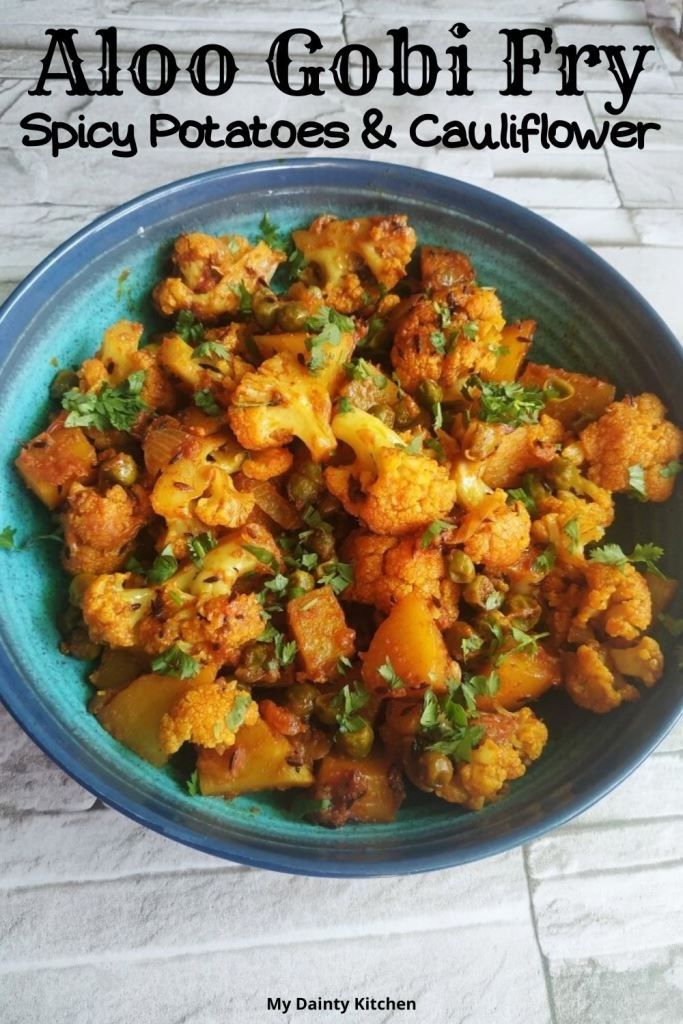 a blue bowl filled with cauliflower and potatoes on top of a white table