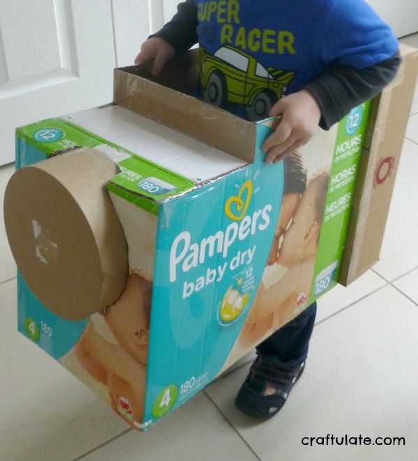 a young boy is playing with a box made out of diapers and toilet paper