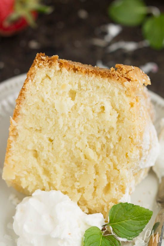 a piece of cake on a plate with whipped cream and green leaves next to it