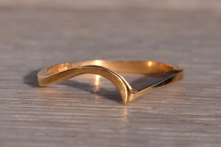 Mount Saint Elias: Wave Ring in Yellow Gold. The ring features a central flowing wave in yellow gold which peaks at the crest of the lowered shank. The ring is crafted in 14 karat yellow gold and is currently a finger size 6.5 yet can be adjusted to any finger size for an additional charge on request. Love this piece, but don't have the money to spend right now?  We offer FREE layaway on every item in our shop.  With just 20% down, take one full year (interest-free) to pay off your new jewelry! Gold Wavy Rings For Gifts, Modern Twist Yellow Gold Stackable Rings For Formal Occasions, Wavy Gold Rings For Gift, Minimalist Curved Gold Jewelry, Modern Gold Rings With Curved Design, Modern Gold Curved Rings, Modern Curved Gold Rings, Curved 14k Gold Jewelry For Anniversary, 14k Gold Curved Jewelry For Anniversary