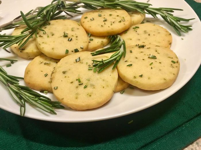 a white plate topped with crackers covered in herbs