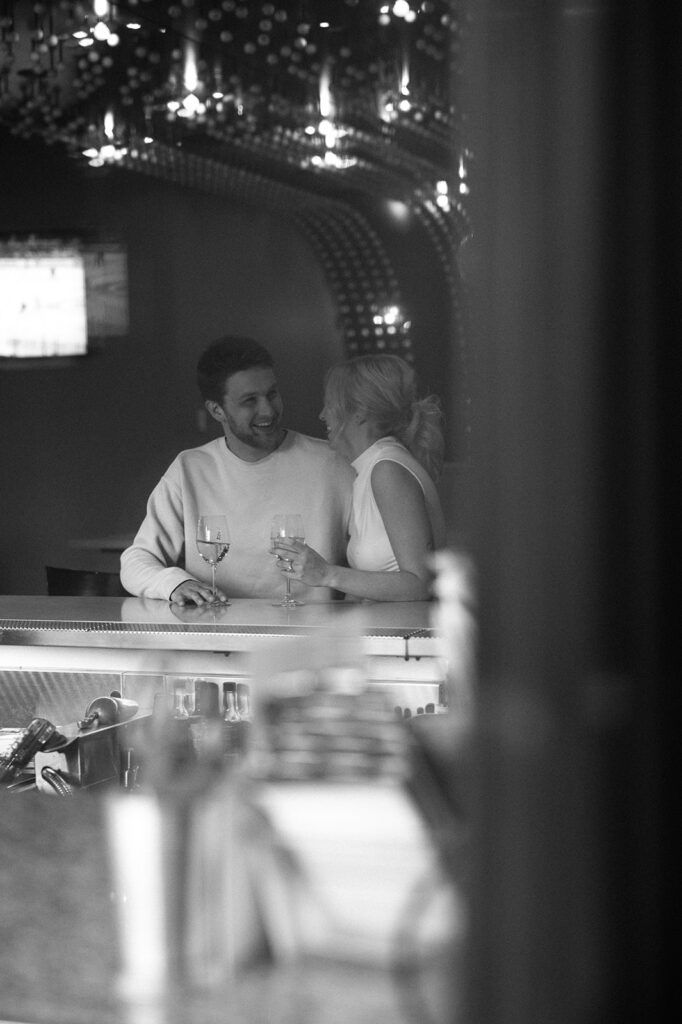 a man and woman sitting at a bar