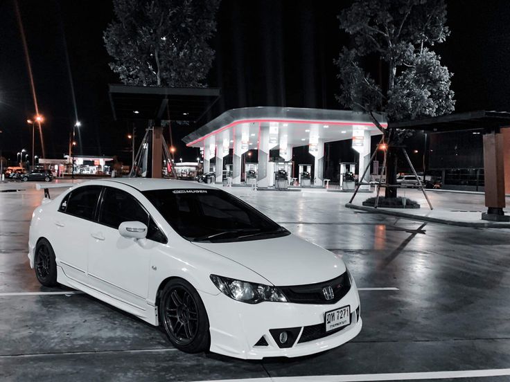 a white car parked in front of a gas station