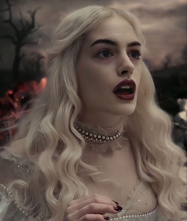 a woman with long blonde hair wearing a choker and pearls on her neck stands in front of a fire