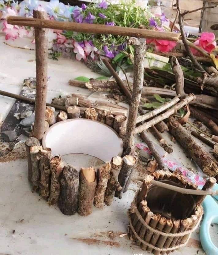 a pile of wood sitting on top of a wooden table next to flowers and scissors