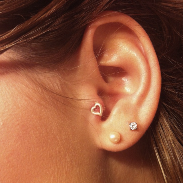 a close up of a person's ear with a diamond in the middle