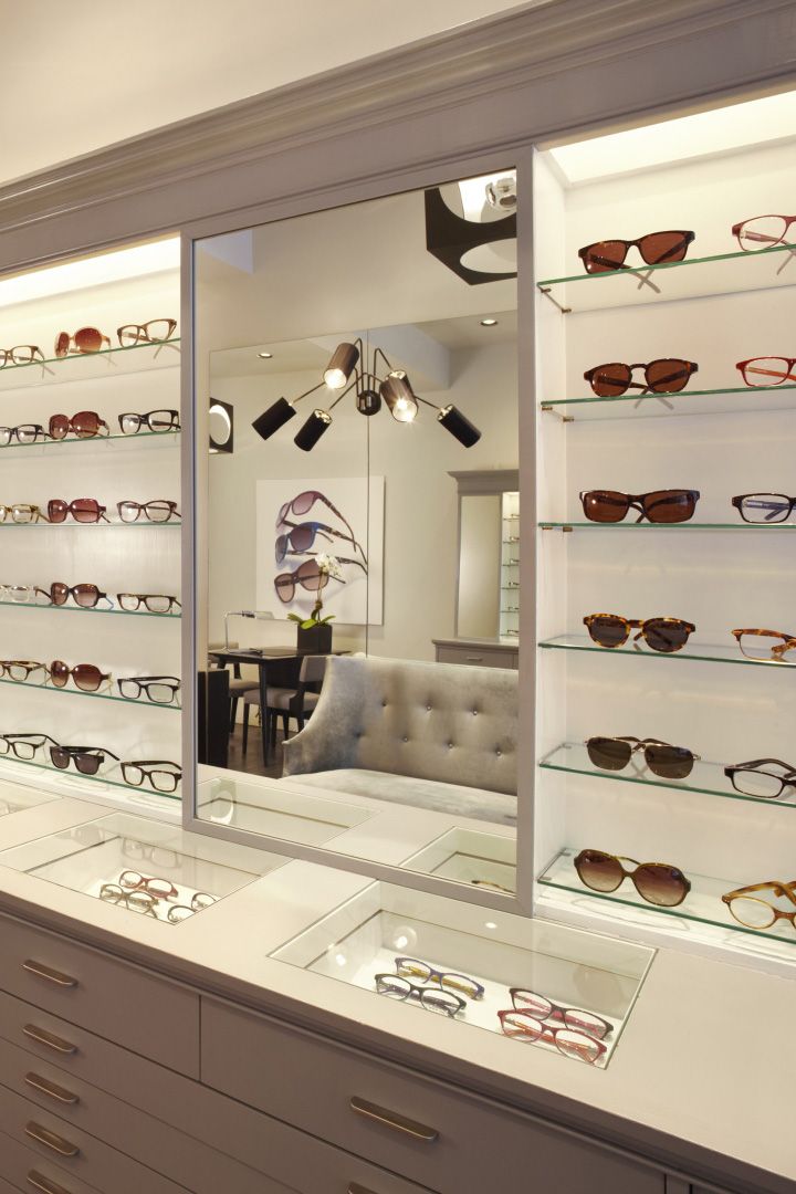 a display case with many pairs of eyeglasses on the shelves in front of it