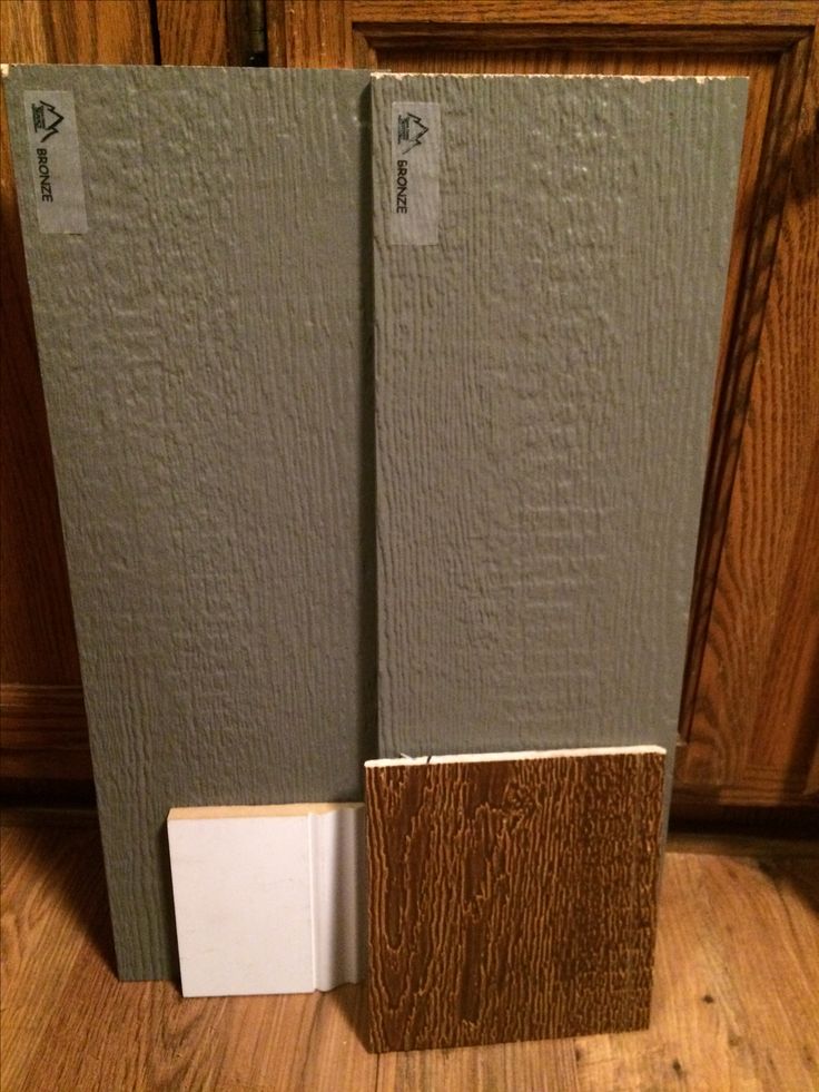 a close up of two doors on a wooden floor with a white door handle and brown wood paneling