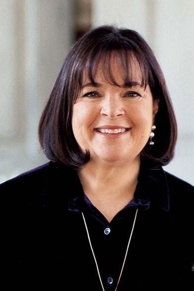 a smiling woman in a black shirt and necklace