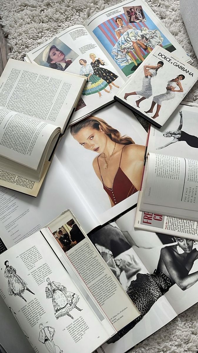 an open book sitting on top of a floor next to many pictures and bookshelves