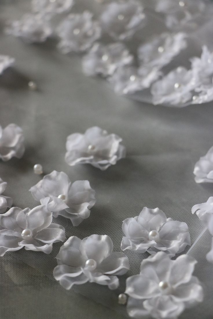 white flowers and pearls are on the fabric