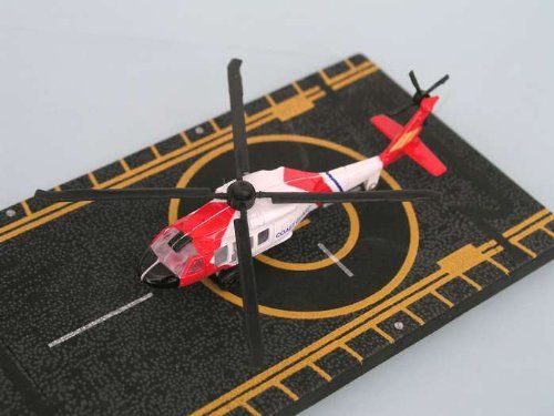 a red and white helicopter is on a black mat with gold trimmings around it