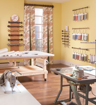 a sewing studio with yellow walls and wooden floors