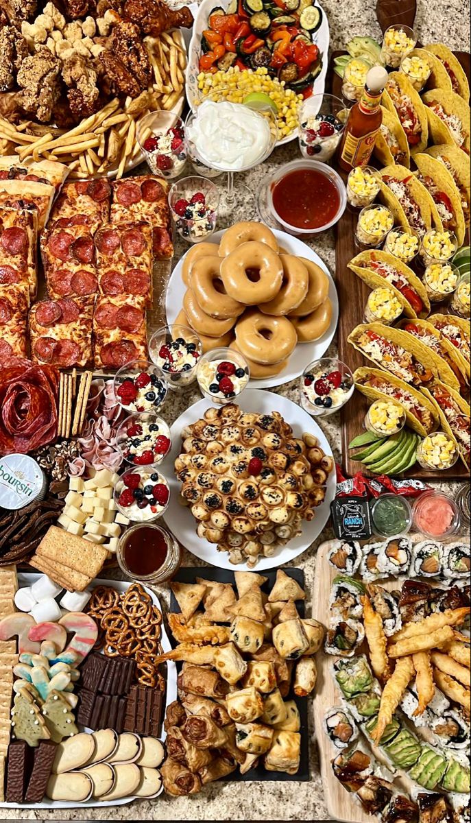 a table filled with lots of different types of food on plates and trays next to each other