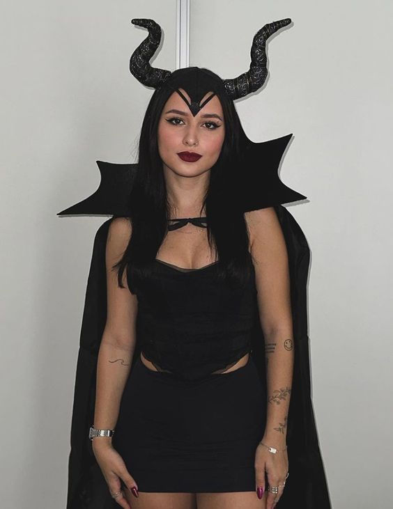 a woman in a black dress with horns on her head and devil's ears