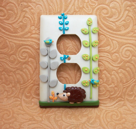 a white and green switch plate cover with a hedgehog design on it's side