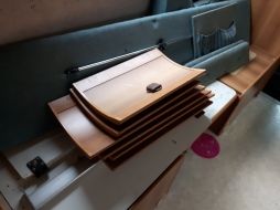 a stack of wooden drawers sitting on top of a floor next to a bed frame