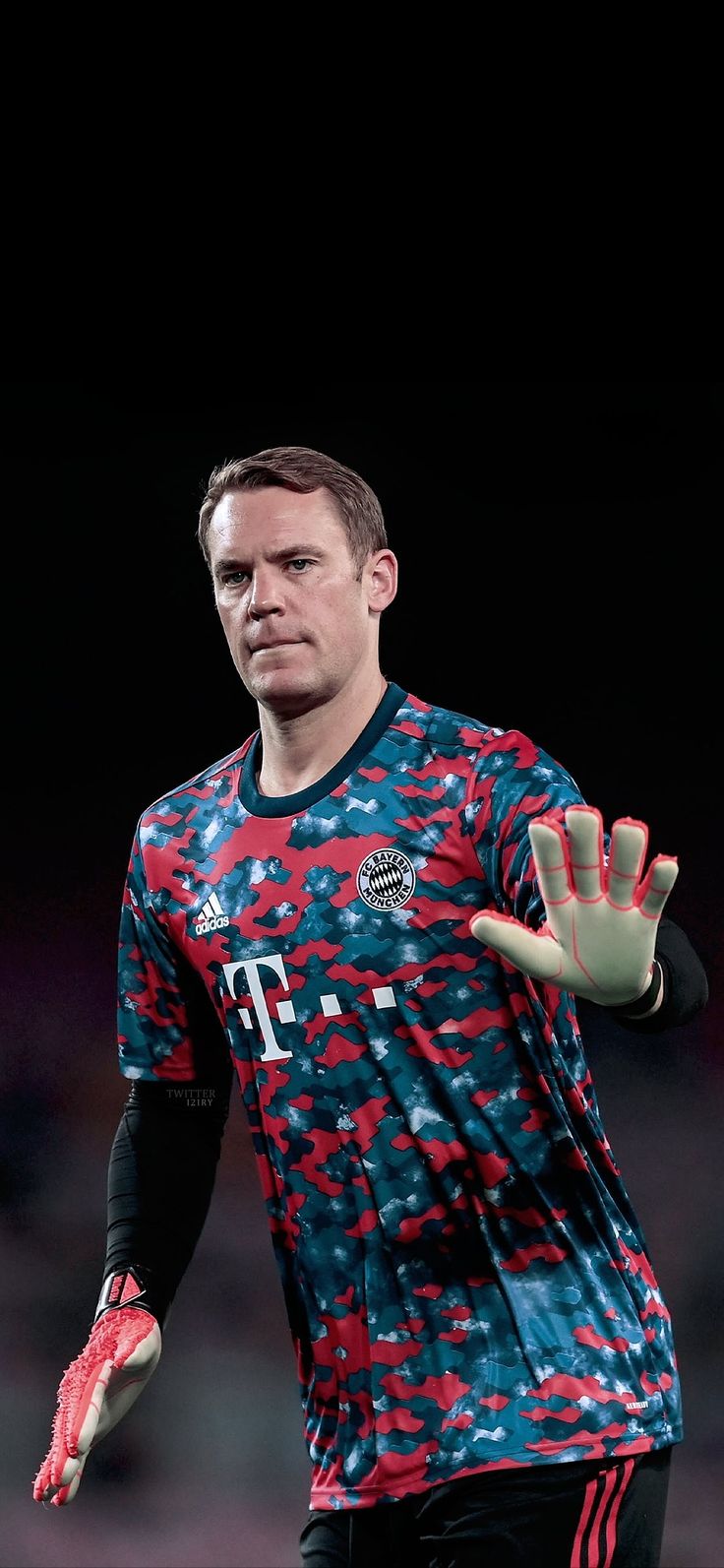 a soccer player is holding his hand up in the air while wearing red and blue gloves