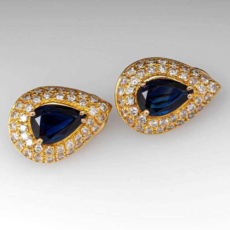 These gorgeous sapphire earrings are each centered with a pear cut sapphire in a four-prong setting. The center is accented by forty (40) bead set, round brilliant cut diamonds. The earrings measure 18.9mm long by 13.6mm wide and 6.2mm deep, finished with omega style clip on backs. We can add a post for pierced ears if you prefer. Formal Sapphire Diamond Earrings With Diamond Accents, Classic Teardrop Jewelry With Gemstone Accents, Classic Teardrop Gemstone Jewelry, Elegant Diamond Earrings With Gemstone Accents For Anniversary, Elegant Sapphire Diamond Earrings For Anniversary, Elegant Sapphire Diamond Earrings For Formal Occasions, Blue Teardrop Diamond Earrings For Anniversary, Classic Blue Diamond Earrings For Formal Occasions, Teardrop Sapphire Earrings For Anniversary