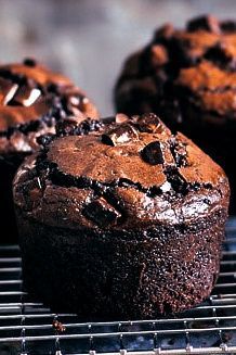 three chocolate muffins cooling on a wire rack