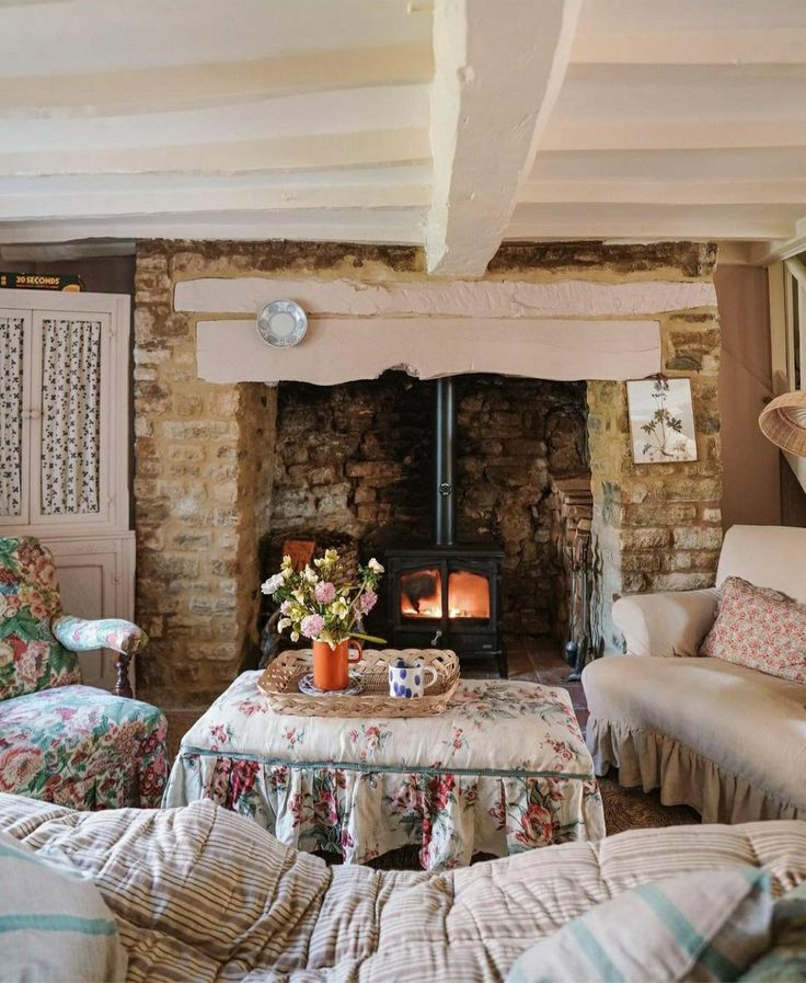 a living room filled with furniture and a fire place in the middle of it's wall