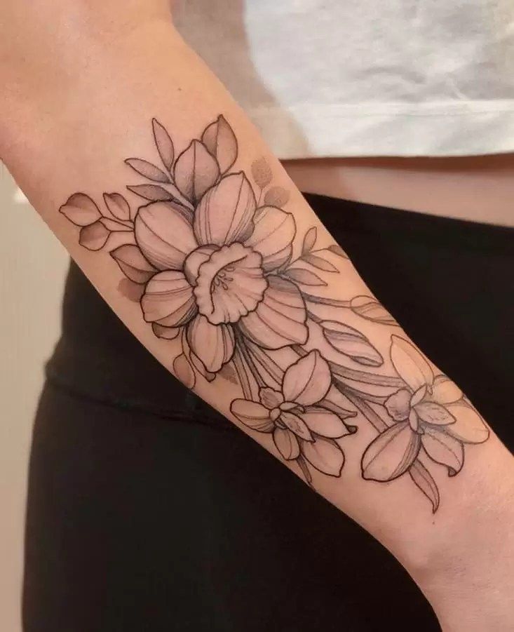 a woman's arm with a flower tattoo on the left side of her arm