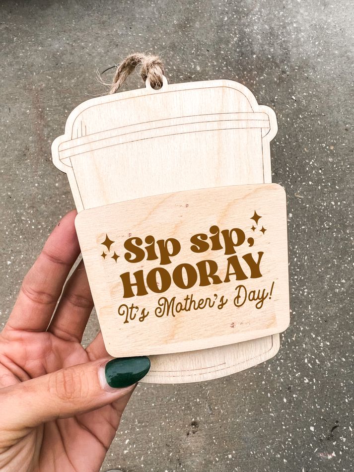 a hand holding a wooden sign that says sip sip hooray it's mother's day