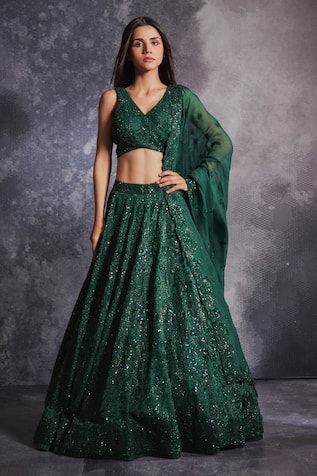 Topaz green flared lehenga with all over floral pattern, tonal sequin, glass beads and stone embroidery. Paired with embroidered blouse with overlap panel and dupatta.
Components: 3
Pattern: Embroidered
Type Of Work: Sequin, Glass Beads and Stone Work
Neckline: Sweetheart Neck
Sleeve Type: Sleeveless
Fabric: Silk Organza 
Color: Green
Other Details: 
Cut work dupatta hem
Inverted V blouse hem
Wrap blouse
Closure: Blouse: Back tie-up
Note: The outfit worn by the other model on the right is not fo Anarkali Green Lehenga With Sequins, Green Sequined Choli For Reception, Designer Green Sequined Lehenga, Festive Green Lehenga With Sequins, Festive Green Sequined Lehenga, Fitted Green Sequined Set, Green Sequined Floor-length Lehenga, Green Anarkali Style Choli With Sequins, Fitted Green Lehenga With Sequins