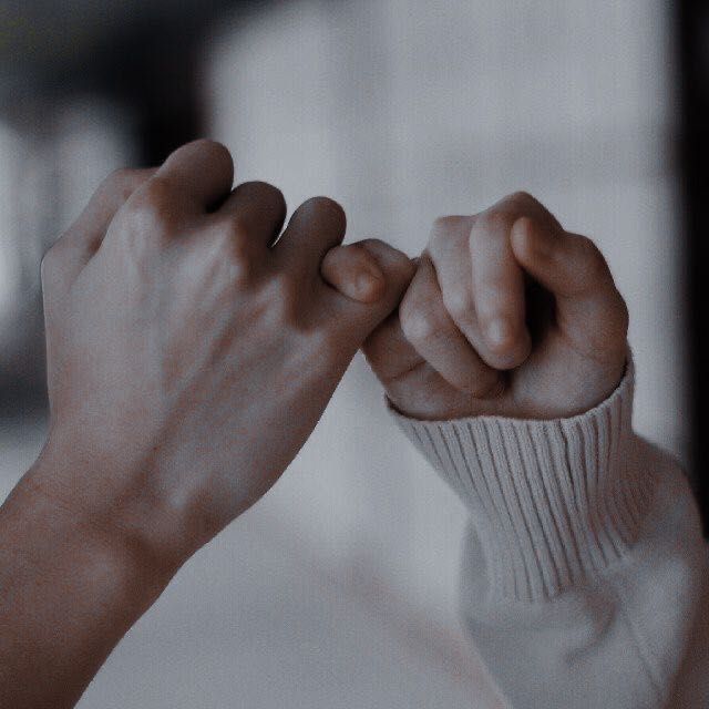 two hands holding each other in the middle of a fist bumping between their fingers