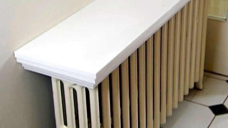 a white radiator sitting on top of a tiled floor