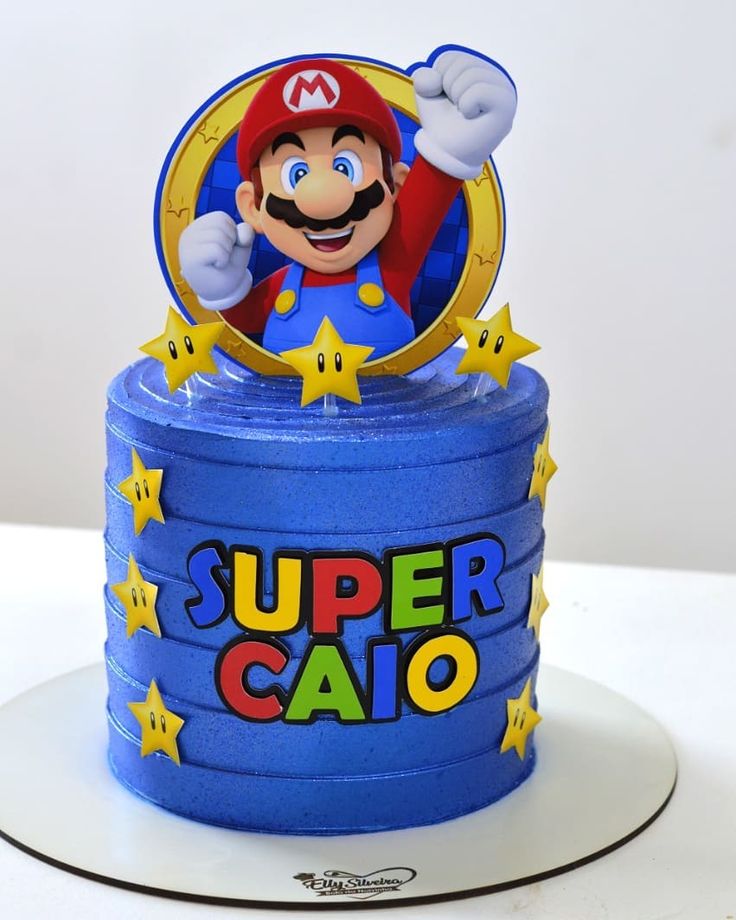 a super mario birthday cake on top of a blue box with stars around the base