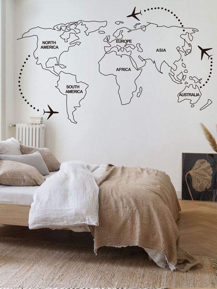 a bedroom with a bed and a wall sticker that says the world on it