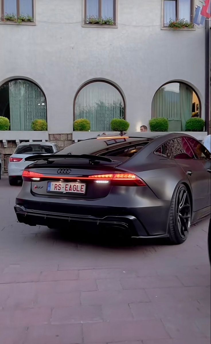 a black sports car parked in front of a building