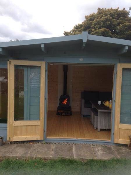 an outdoor living area with patio furniture and wood burning stove in the back door open