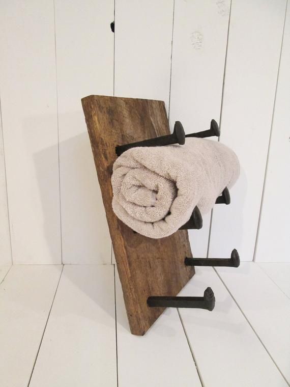 a towel rack with two towels hanging on it's sides and one folded up