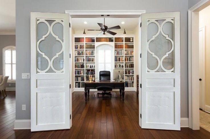 an open door leading to a home office with a desk and bookcase in the background