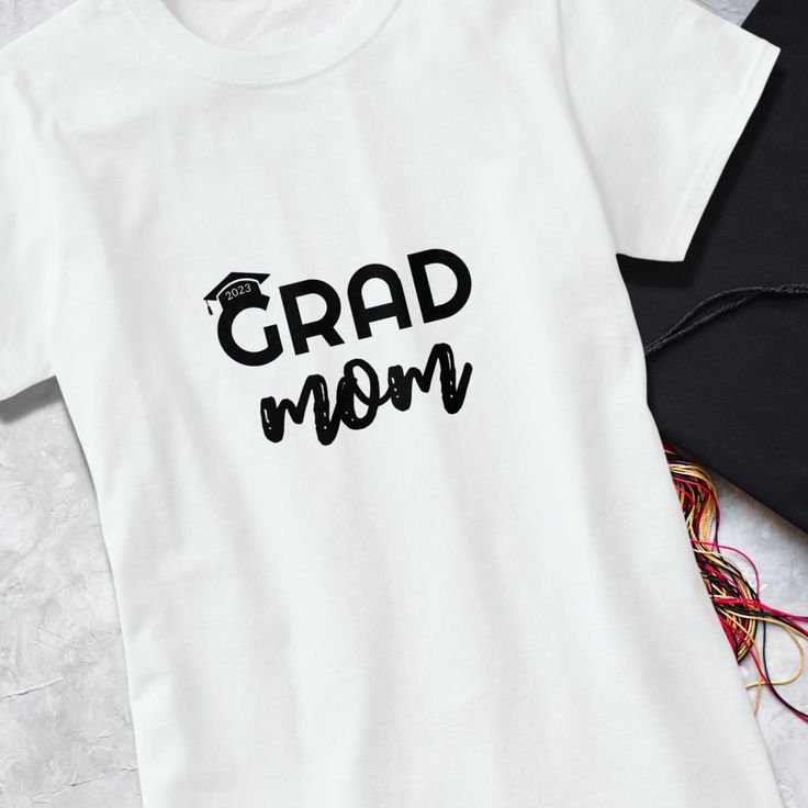 The perfect t-shirt for all the proud graduate mothers out there! Our "Grad Mom" t-shirt is a stylish and trendy way to show your support for your class of 2023 graduate. The shirt features the words "Grad Mom" in bold and eye-catching text, making it easy for everyone to see your pride from a distance. The design also includes a graduation cap graphic that sits on top of the letter G in "Grad," with the year 2023 displayed on it.
Whether you're attending your child's graduation ceremony, celebr School Spirit Crew Neck T-shirt For Graduation Party, Pre-shrunk Cotton T-shirt For Graduation Party, School Spirit T-shirt With Graphic Print For Graduation, Casual T-shirt With Text Print For Graduation, Graduation Letter Print Crew Neck T-shirt, White T-shirt With Letter Print For Graduation, Letter Print T-shirt For Graduation, Crew Neck T-shirt With Graphic Print For Graduation Party, Black Letter Print T-shirt For Graduation