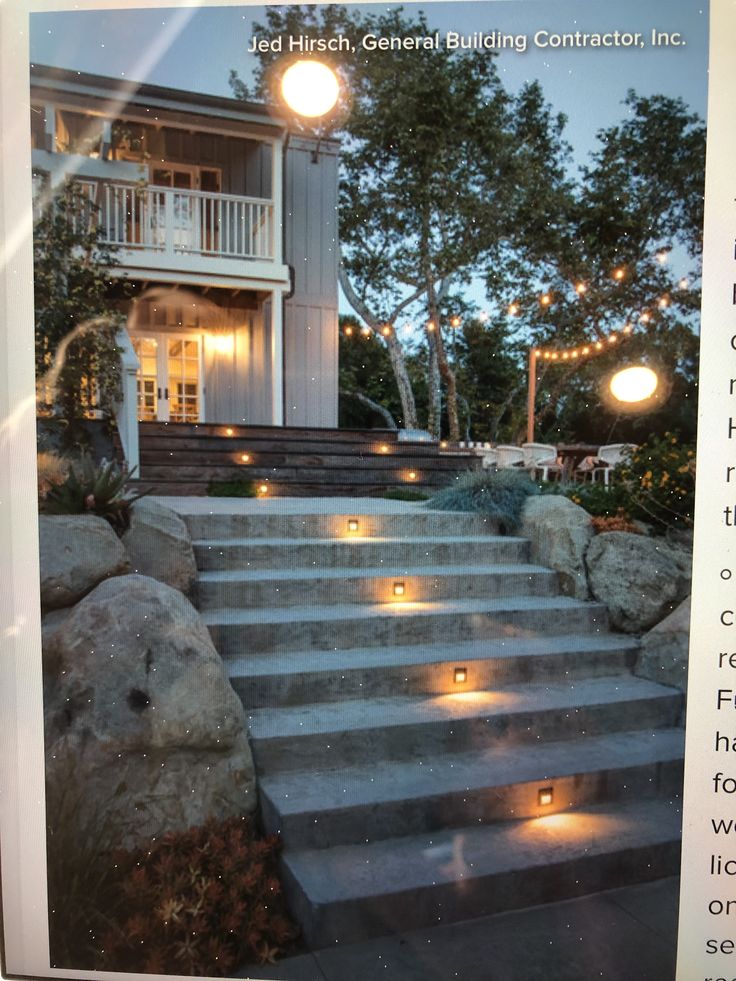 some lights that are on the steps in front of a house with stairs leading up to it