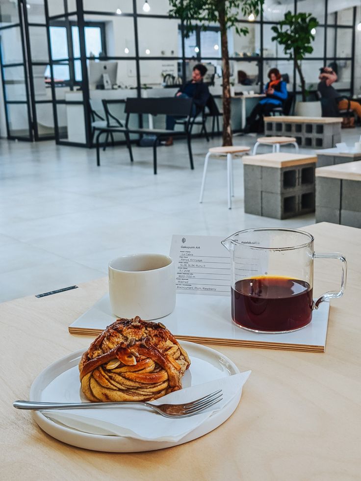 a plate with some food on it next to a cup of coffee