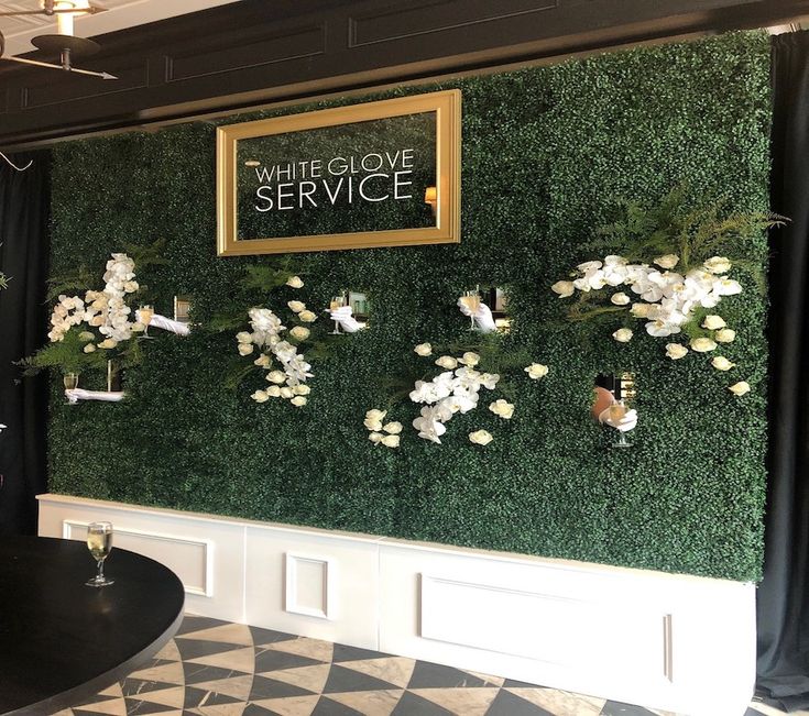 a black and white checkered floor in front of a green wall with flowers on it