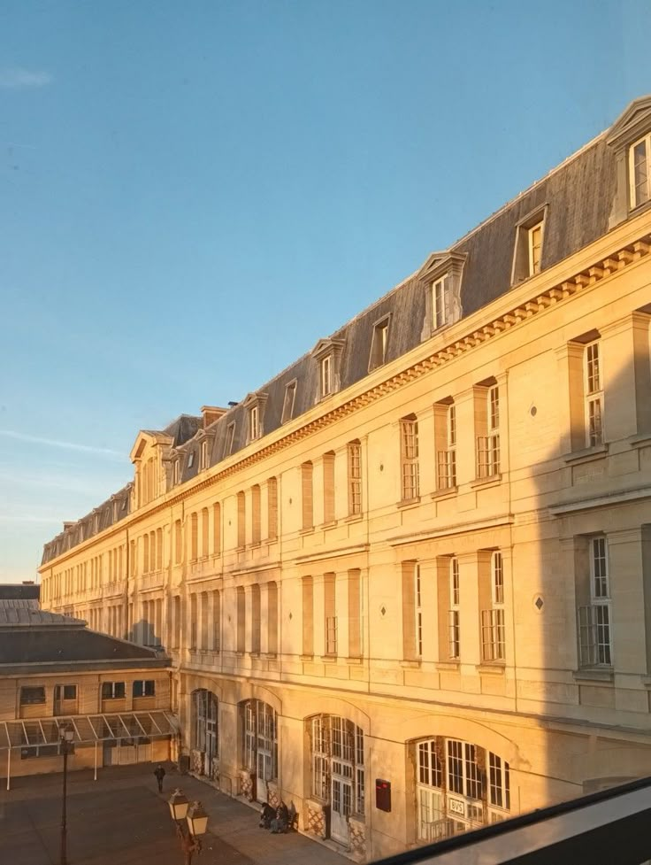 the sun is shining on an old building with many windows and balconies in front of it