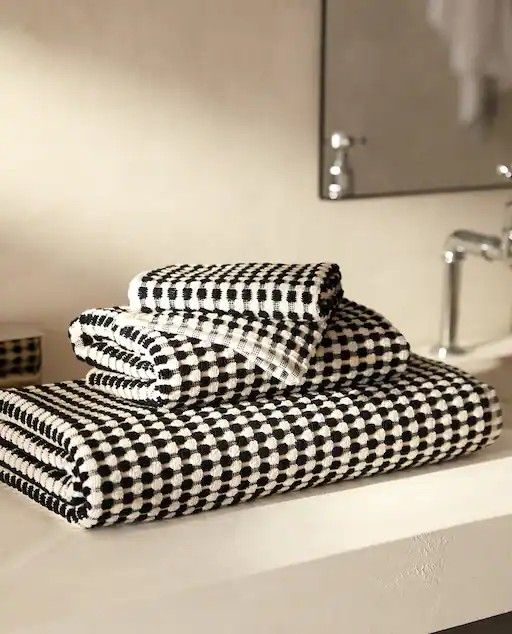 two black and white towels sitting on top of a counter