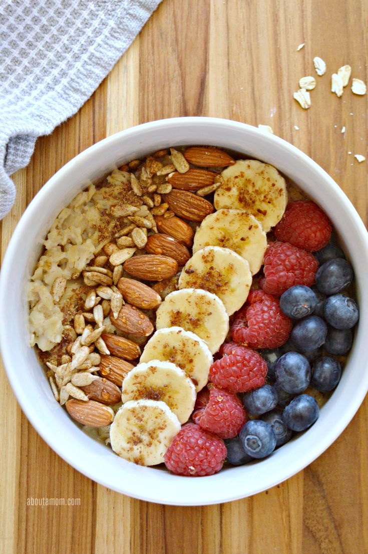 a bowl filled with fruit and nuts on top of a wooden table