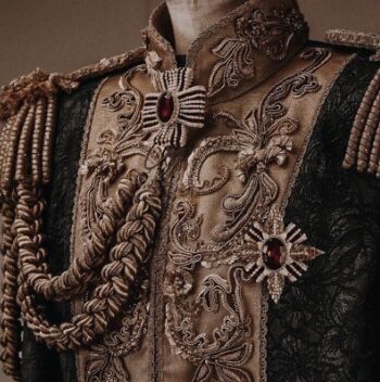 an elaborately decorated jacket is shown with beads and chains on the collar, as well as