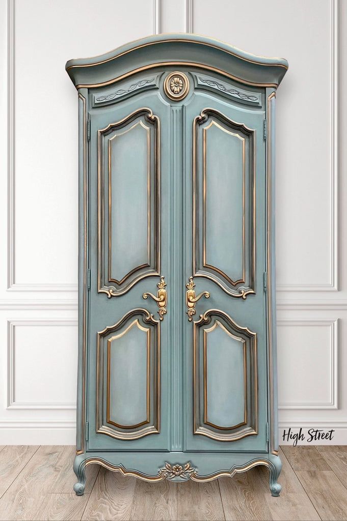 an old blue armoire with gold trim