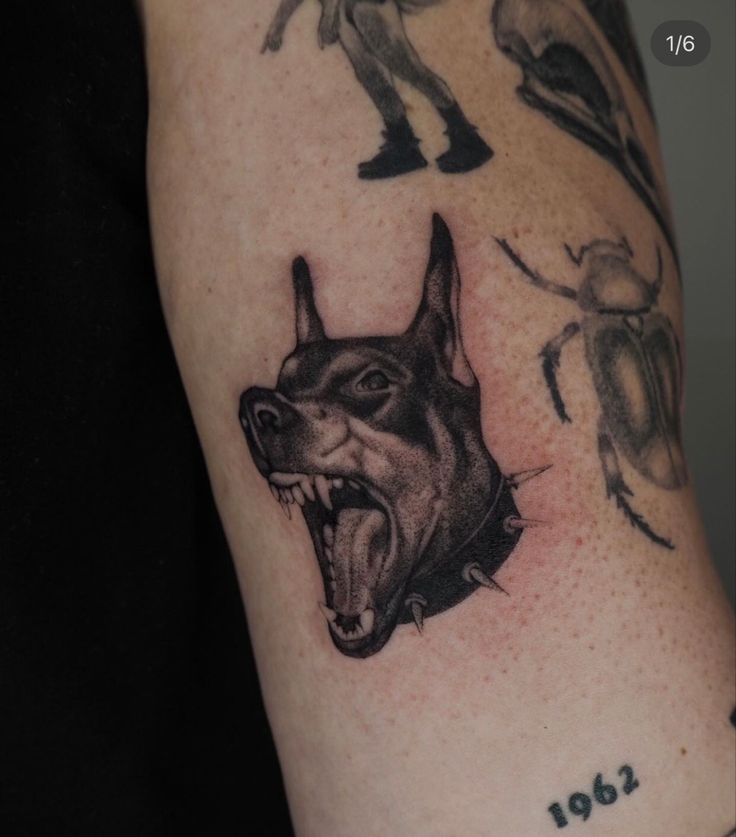 a tattoo with an image of a dog on it's arm and two bugs in the background