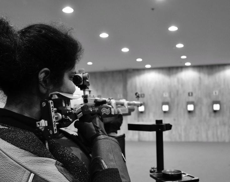 a woman is looking through a telescope at something in the distance while another person looks on