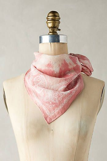 a mannequin wearing a pink and white scarf on top of a wooden dummy