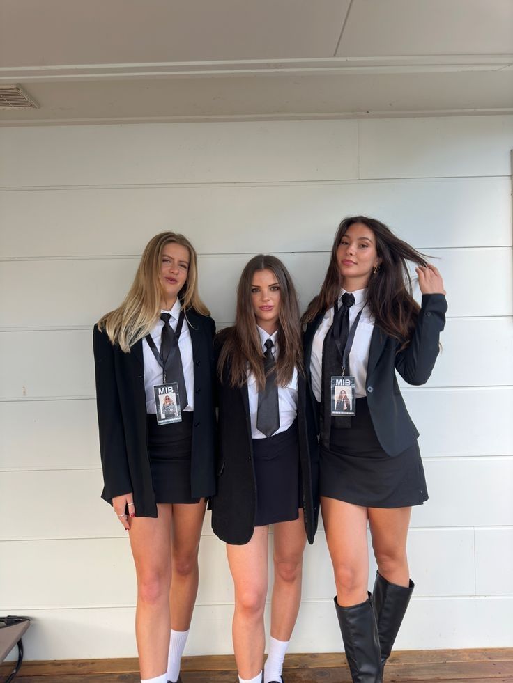 three young women dressed in school uniforms posing for a photo with their hands on their hipss