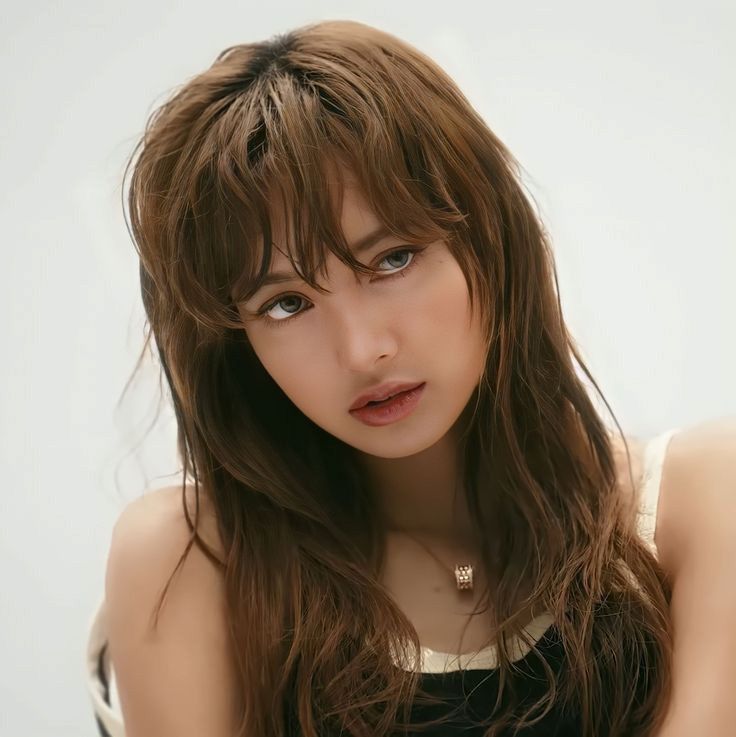 a woman with long brown hair posing for the camera